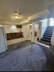 A wide view of an entire dirty and outdated basement area before a full renovation by Inside Out Commercial Solutions in Cleveland, OH.