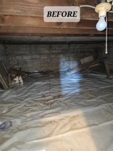 A cluttered crawl space filled with debris and wood scraps before junk removal by Mike And Nick's Removal Service in Milwaukee, WI