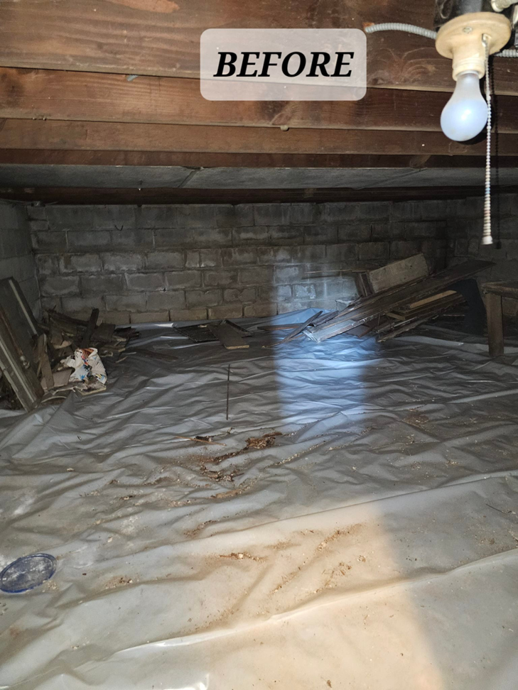 A cluttered crawl space filled with debris and wood scraps before junk removal by Mike And Nick's Removal Service in Milwaukee, WI
