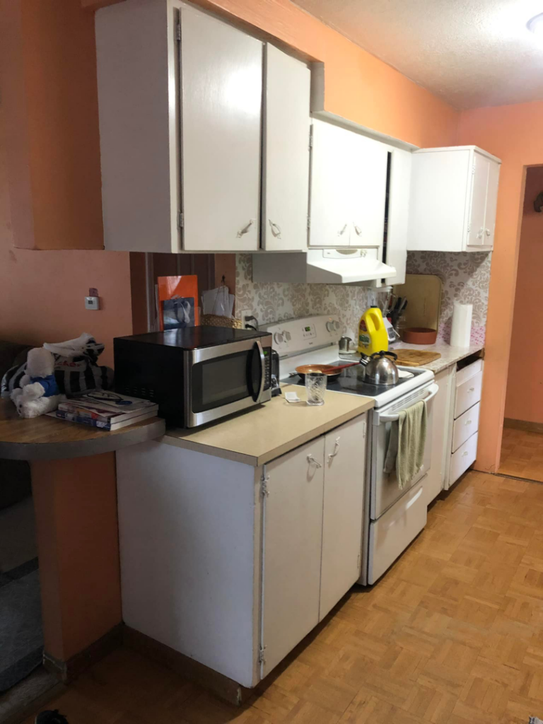 Before kitchen remodel showing old white cabinets and stove area by All in One Remodeling Services LLC in East Sandwich, MA