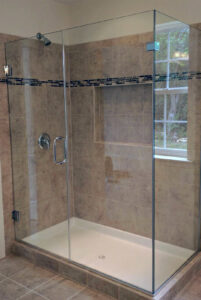 A beige tiled frameless shower with a convenient built-in niche, completed by Lehigh Shower Glass in Bethlehem, PA
