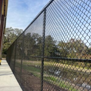 A durable black chain-link fence installed along a waterfront by Keeler Fence in New Port Richey, FL.