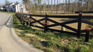 A black crossbuck style fence installed along a residential road by Premier Fence Company in Glen Allen, VA.