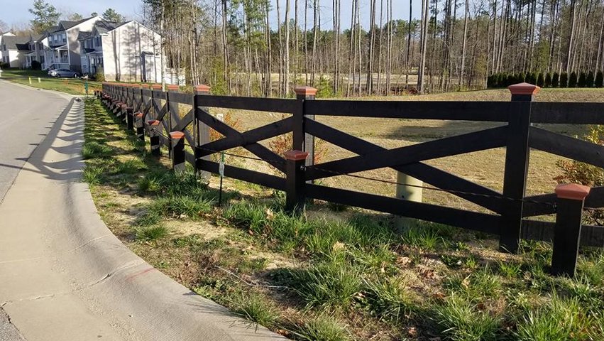 A black crossbuck style fence installed along a residential road by Premier Fence Company in Glen Allen, VA.