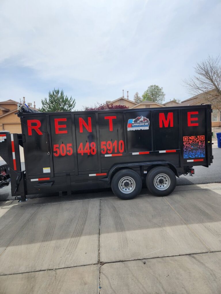 A black dump trailer with 'RENT ME' and the Jigsaw Transport and Waste logo, available for rent in Albuquerque, NM.