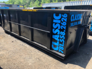 A large black dumpster with 'Classic Disposal' branding, ready for junk removal in Malden, MA.