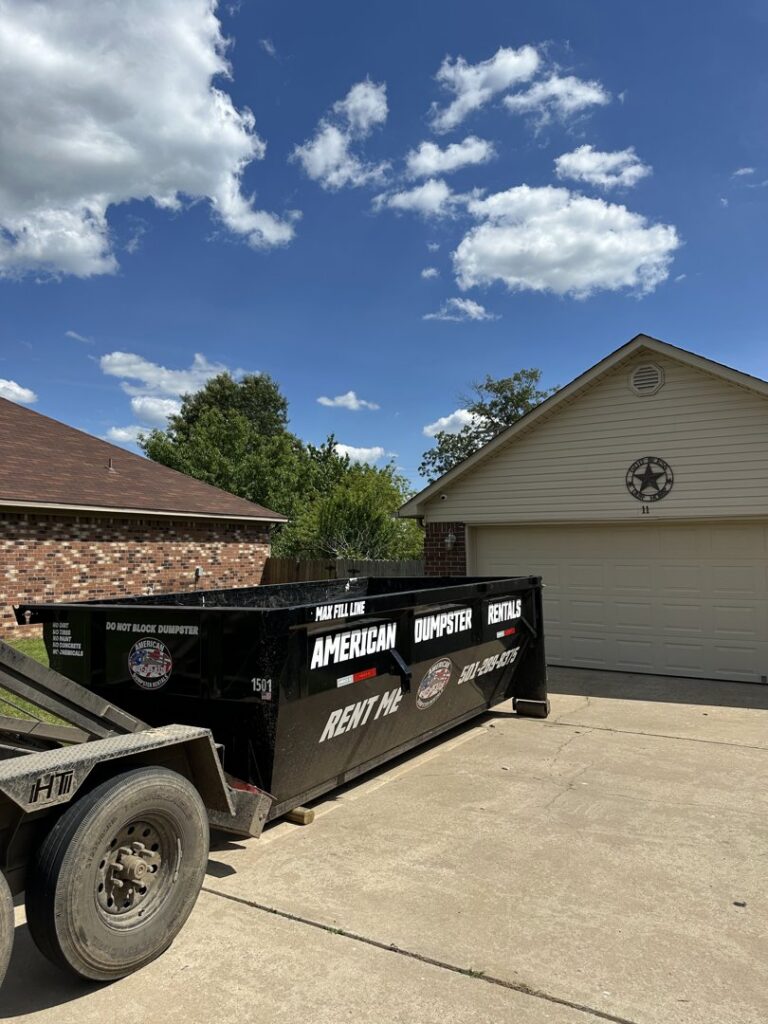 A black dumpster from American Dumpster Rentals placed in a residential driveway in Morrilton, AR.