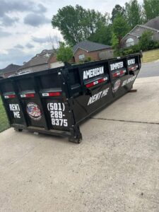 A black dumpster from American Dumpster Rentals placed in a residential driveway in Morrilton, AR.