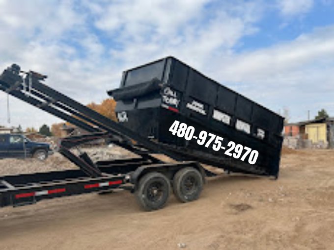 A black dumpster trailer being loaded onto a truck by Easy Load Disposal El Paso for junk removal service in El Paso, TX.