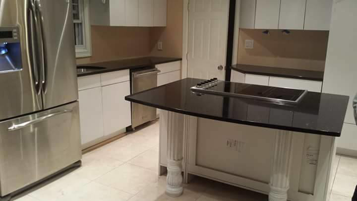 A modern kitchen featuring newly installed black granite countertops by LJ Marble & Granite in Paterson, NJ.