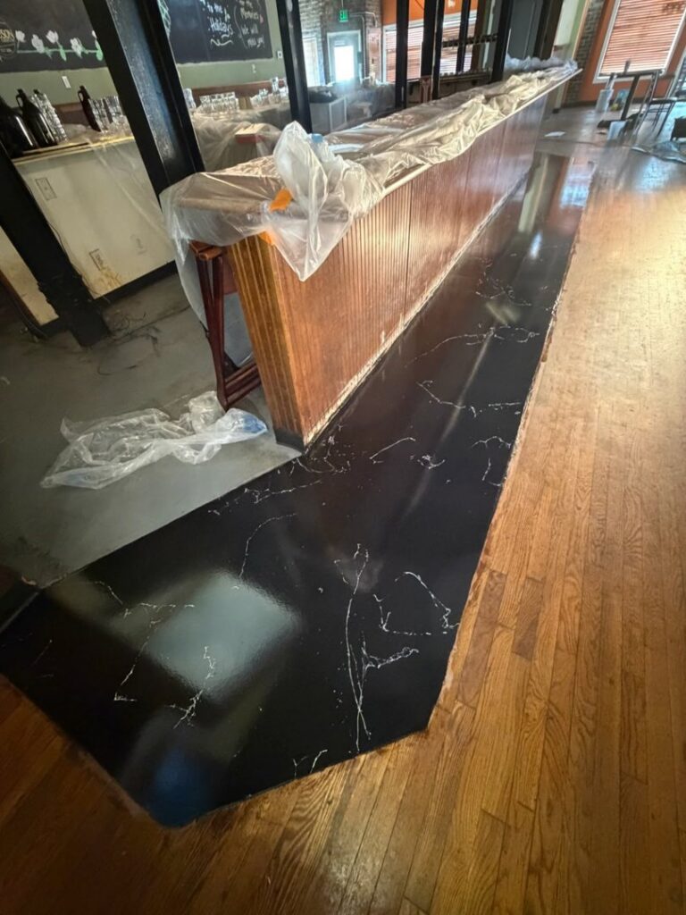 A sleek black marble-look epoxy bar countertop installed by Donnelly J. LLC Epoxy in St. Charles, MO.