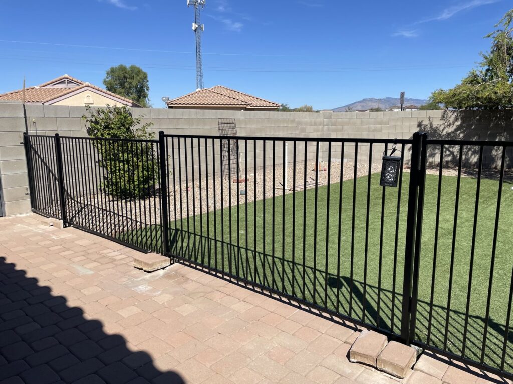 A black metal backyard fence and gate installed by Affordable Fence & Gates in Tucson, AZ.