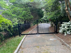 A newly installed black metal driveway gate with an automatic opener by Minors Fences in Ashland, VA.