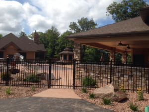 A sturdy black metal fence and gate enclosing an outdoor living area, built by Ankeny Builders L.L.C. in Eau Claire, WI.