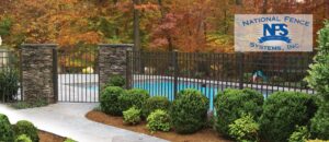 Custom black metal pool fence with elegant stone pillars and gate by National Fence Systems, Inc. in Avenel, NJ.