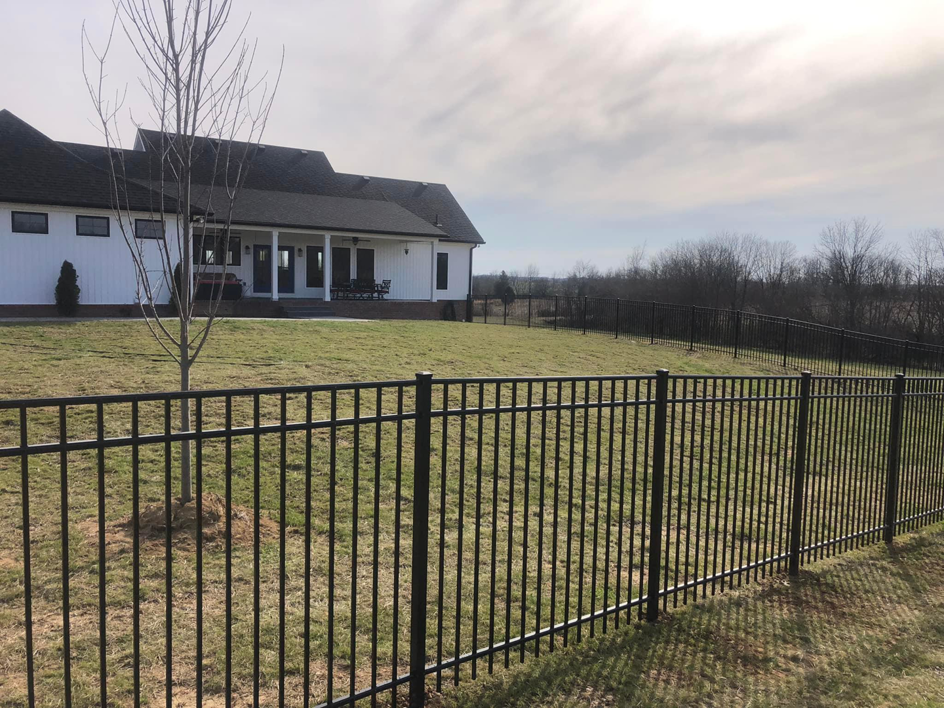 A newly installed black metal fence surrounding a large residential property by Fence & More in Elizabethtown, KY