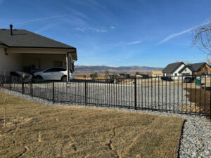 A black metal security fence installed by GreenView Solutions in Denver, CO, with mountain views.