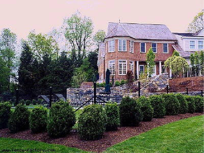 A black metal security fence installed around a large residential property by Fence Factory Inc in Stamford, CT