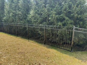 A durable black metal security fence installed along a grassy slope by Lee Fence and Outdoor in York, PA.