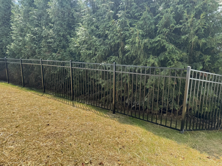 A durable black metal security fence installed along a grassy slope by Lee Fence and Outdoor in York, PA.
