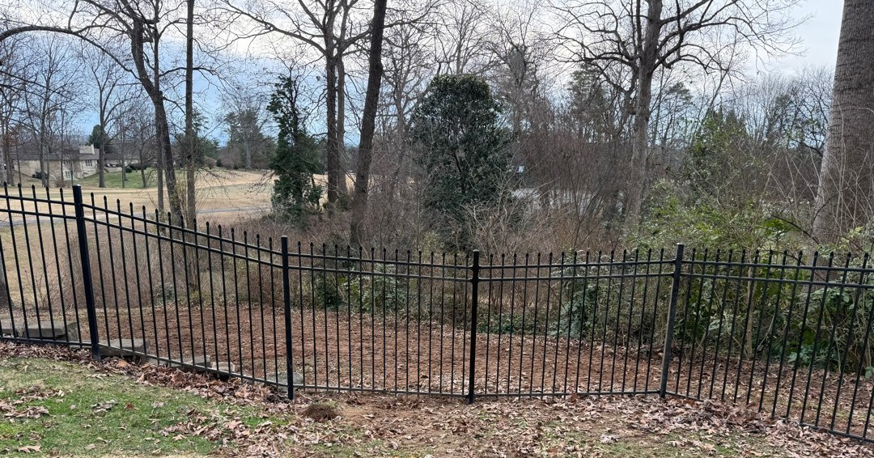 A black ornamental metal fence installed in a residential backyard by Tim's Fencing in Knoxville, TN.