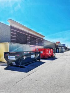 Black and red dumpsters from 515 Dumpsters in a commercial area in West Des Moines, IA.