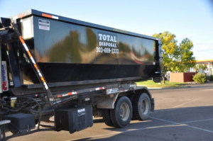 A black roll-off dumpster on a truck for Total Disposal of Denver - Roll Off Dumpsters in Arvada, CO.