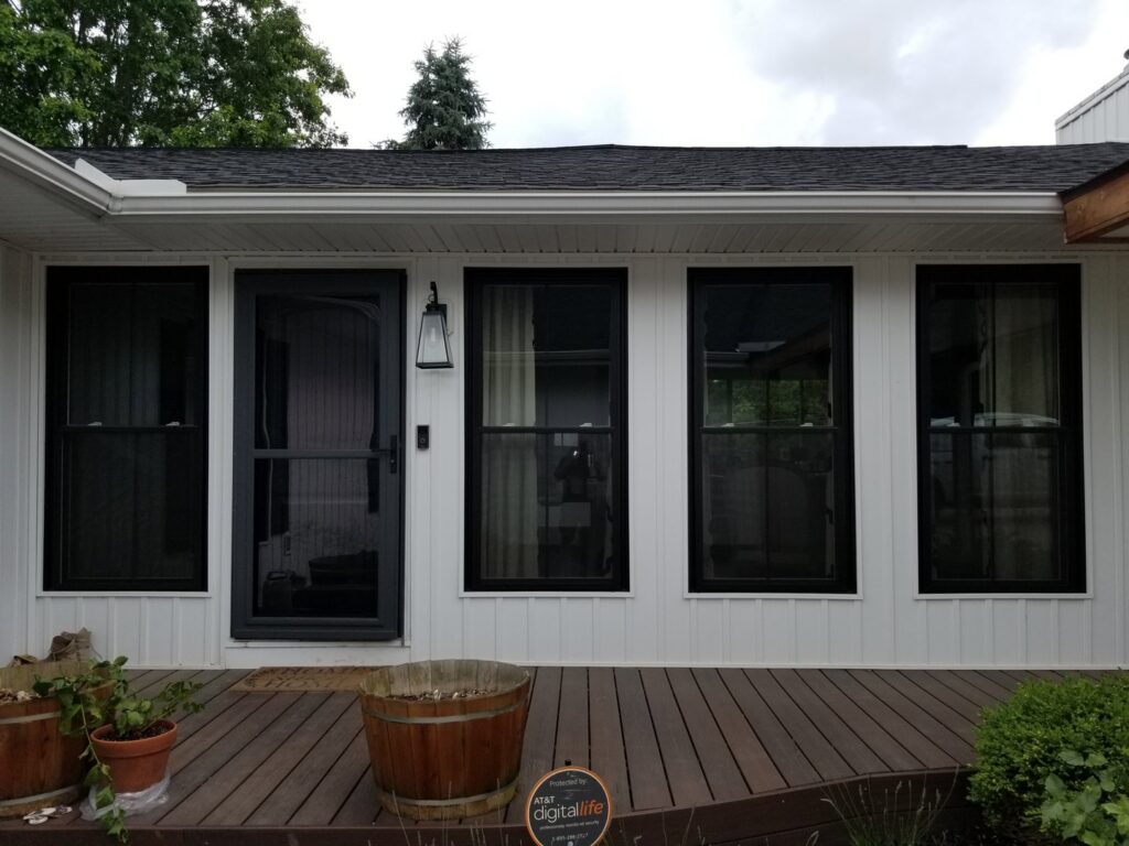 A newly installed black storm door and black windows on a white house by The Window Man of Ohio in Westerville, OH.