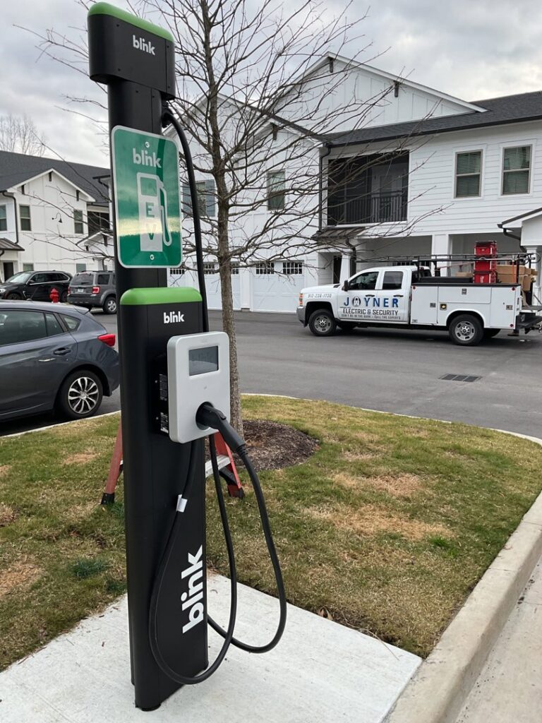 A Blink EV charging station with a Joyner Electric And Security service truck in the background in Savannah, GA.