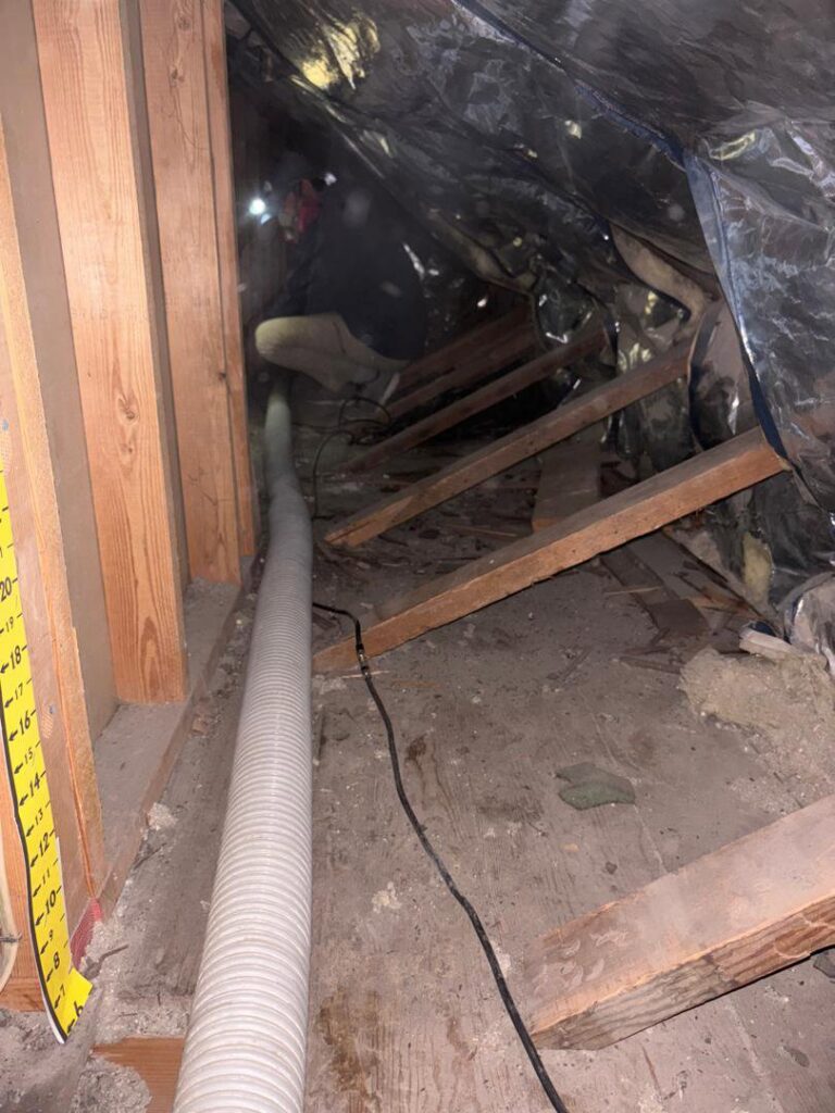 A hose actively blowing insulation into an attic space, a service provided by Pacific Insulation & Mold Remediation in Spokane, WA.