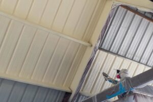 A worker blowing loose-fill insulation into a ceiling cavity during an installation by Absolute Pro Insulation in Corpus Christi, TX.