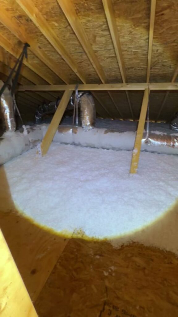 Blown-in insulation covering an attic floor with visible ductwork by Insulation By Cohen's in Moncks Corner, SC.