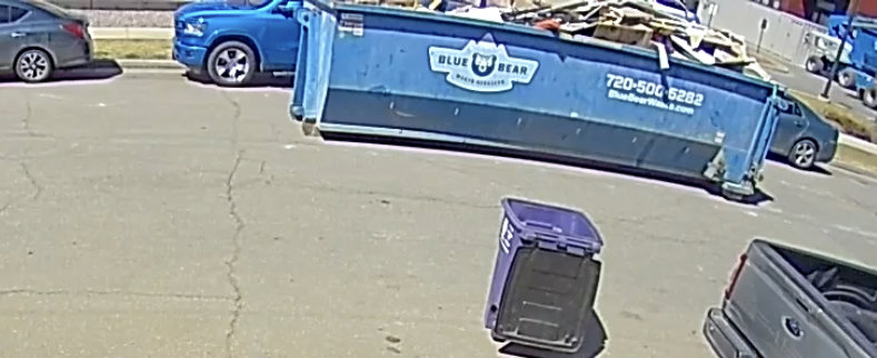 An overhead view of a Blue Bear Waste Services dumpster full of debris on a street in Denver, CO.