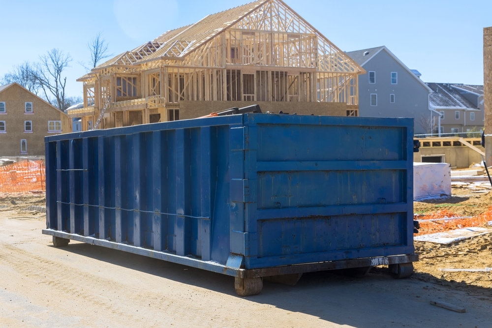 A large blue roll-off dumpster placed at a residential construction site for debris removal by Dumpster 360 in Clarksville, TN.