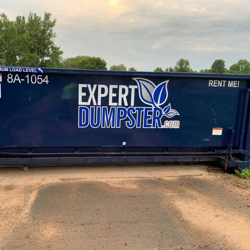 A large blue roll-off dumpster from Expert Dumpster, ready for junk removal in Rochester, NY.