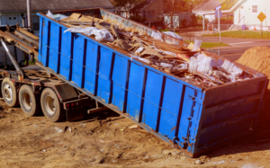 A large blue dumpster filled with various junk and debris, ready for removal by Rapid Rubble Removal in Topeka, KS.