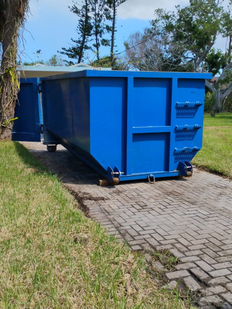 A blue dumpster placed on a paved area for general junk removal by R&Y Dumpster Kings in Tampa, FL.