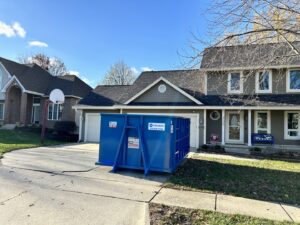 A blue dumpster from 515 Dumpsters placed on a residential driveway in West Des Moines, IA.