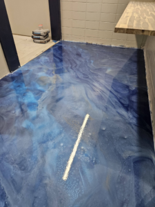 A newly installed blue and gold swirled epoxy floor by New Age Decorative Concrete in Broussard, LA.