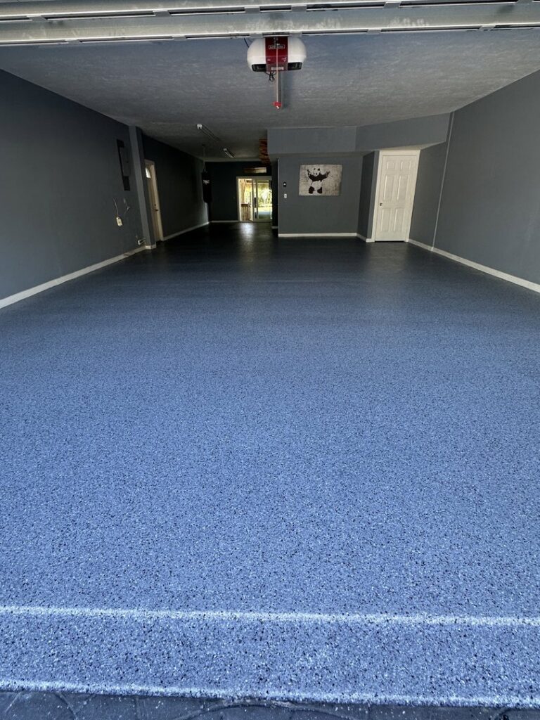 A vibrant blue flake epoxy garage floor expertly installed by Floor Coating Specialist in St. Petersburg, FL.