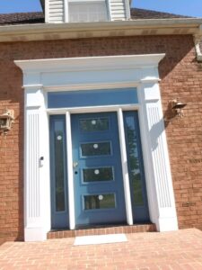 A newly installed blue front door with decorative glass and white trim by The Window Man of Ohio in Westerville, OH.