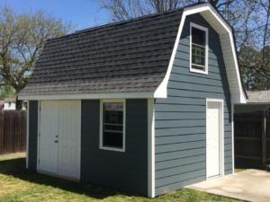 A blue gambrel roof shed with white trim and double doors, expertly constructed by RMG Construction in Chesapeake, VA.