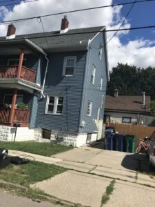 A blue residential house with new siding and a well-maintained exterior, a project by Done Well Home Improvement LLC in Buffalo, NY.