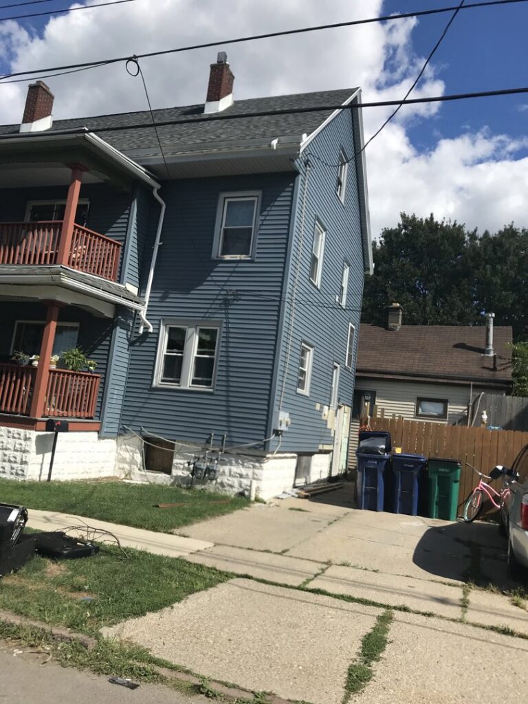A blue residential house with new siding and a well-maintained exterior, a project by Done Well Home Improvement LLC in Buffalo, NY.