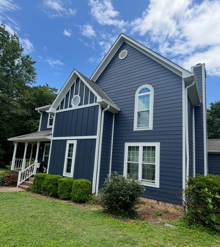 A stunning blue house featuring mixed siding styles and white trim, a completed project by Ideal Siding Richmond, VA.