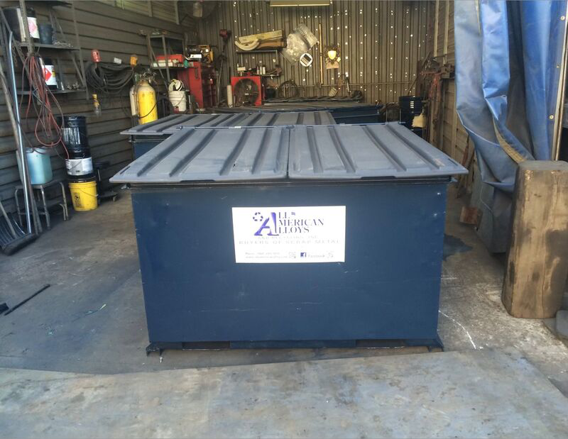 A blue junk removal dumpster with the company logo inside a facility of All American Alloys and Recycling Inc. in Elizabeth, NJ.