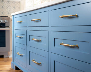 Close-up of blue kitchen island drawers with elegant gold handles, installed by Home Made Easy in Norwalk, CT.