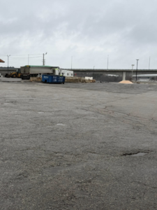A blue roll-off container on a large paved job site provided by East Coast Container Services LLC in Northwood, NH.