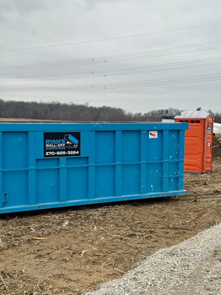 A blue roll-off dumpster from Ryan's Roll-Off Dumpsters on a construction site in Owensboro, KY.