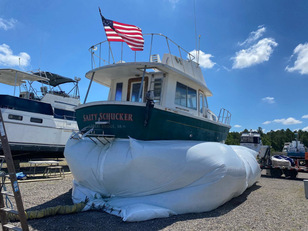 A boat's stern covered with a containment system for eco-blasting surface preparation by Beach Eco Blasting in Virginia Beach, VA.